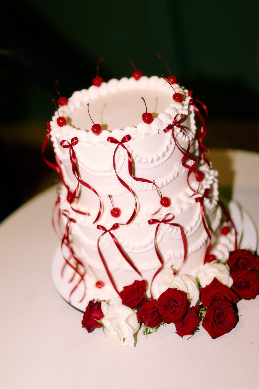 Lambeth-style wedding cake with cherries and red silk ribbons